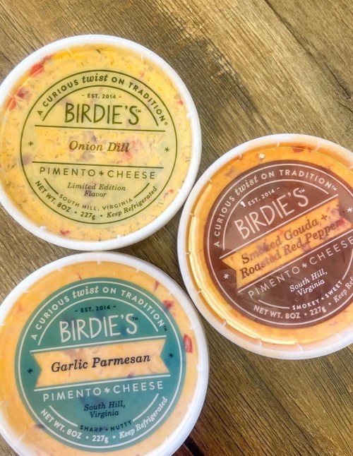 Three containers of Birdie's pimento cheese in flavors: Onion Dill, Garlic Parmesan, and Smoked Gouda Roasted Red Pepper.