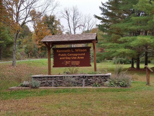 Sign for Kenneth L. Wilson Public Campground and Day Use Area, surrounded by trees and greenery in autumn.