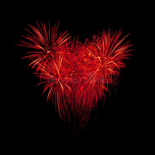 Red fireworks in a heart shape against a black background, creating a festive and romantic atmosphere.