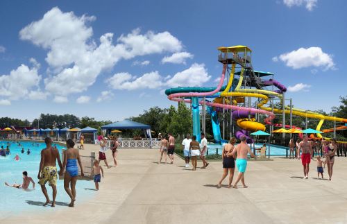 A vibrant water park scene with colorful slides, a pool, and people enjoying the sun and water activities.
