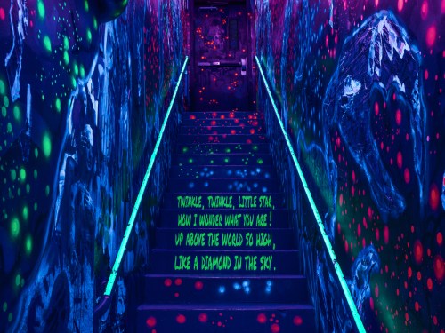 A colorful, graffiti-covered staircase with glowing lights and lyrics from "Twinkle, Twinkle, Little Star" on the wall.