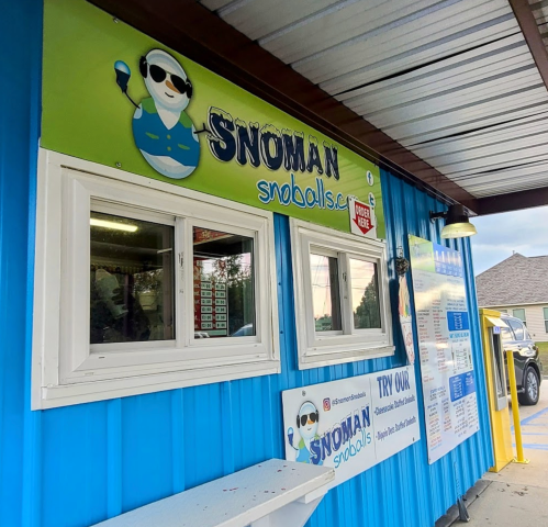 A colorful exterior of a snowball stand named "Snoman" with a cartoon snowman logo and menu displayed.