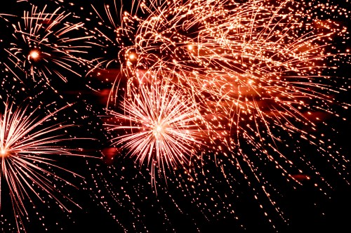 Colorful fireworks burst in the night sky, creating a dazzling display of light and sparks.