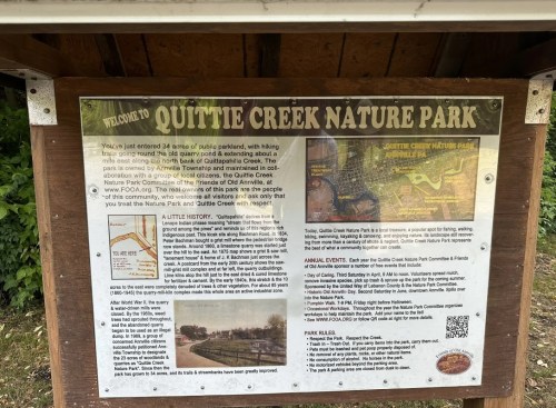 Sign at Quittie Creek Nature Park welcoming visitors and providing information about the park's history and features.