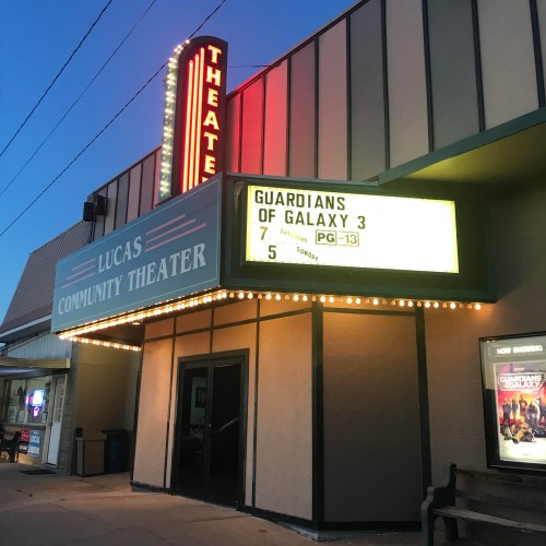 The exterior of Lucas Community Theater with a marquee displaying "Guardians of Galaxy 3" showtimes.