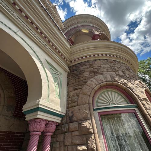 Close-up of a historic building featuring ornate stonework, decorative arches, and colorful architectural details.