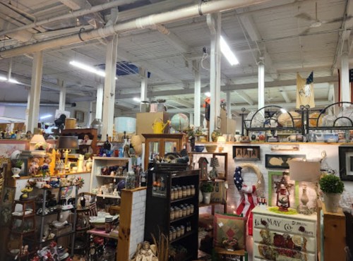 A vibrant antique shop filled with various vintage items, decor, and furniture displayed on shelves and tables.