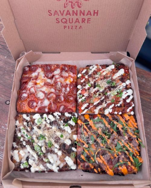 A pizza box containing four square slices, each topped with different ingredients and sauces.