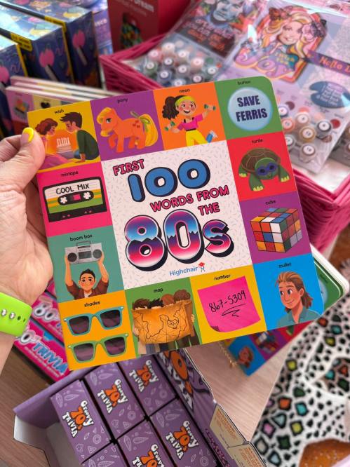 A colorful children's book titled "First 100 Words from the 80s," featuring retro illustrations and items from the decade.