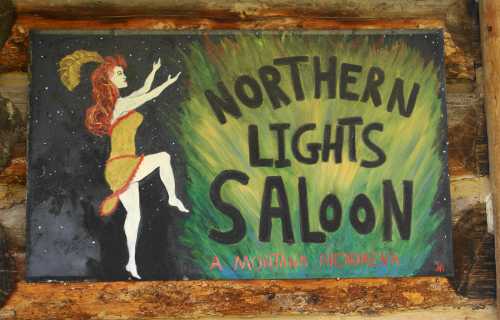 A colorful sign for the "Northern Lights Saloon" featuring a dancer against a vibrant background.