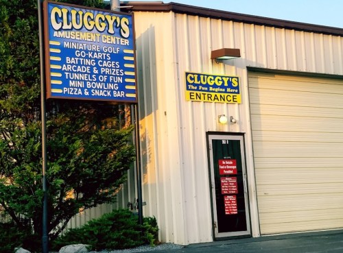 Signage for Cluggy's Amusement Center featuring attractions like mini golf, go-karts, and a snack bar.