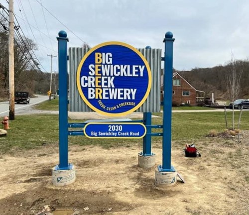 Sign for Big Sewickley Creek Brewery, featuring blue and yellow colors, located at 2030 Big Sewickley Creek Road.