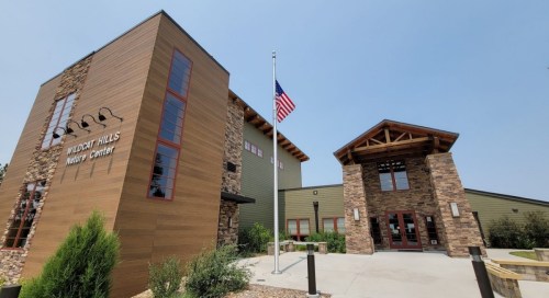 Exterior view of the Wildcat Hills Nature Center, featuring modern architecture and an American flag.