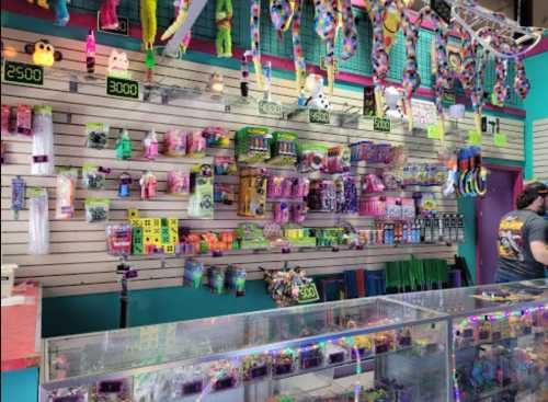 A colorful store display filled with toys, party supplies, and neon items, with price tags visible on the wall.