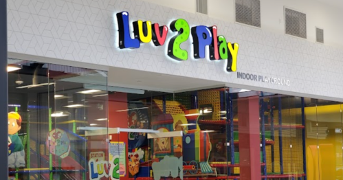 Colorful sign for "Luv 2 Play" indoor playground, featuring playful design and bright colors.