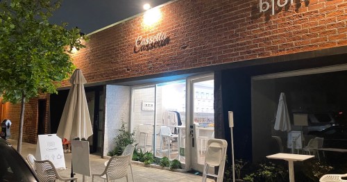 Exterior of a restaurant named "Cassetta," featuring outdoor seating and a warm, inviting atmosphere at night.