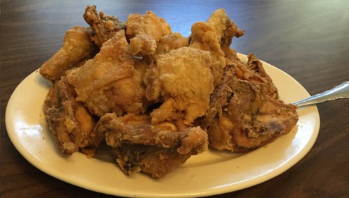 A plate of crispy, golden-brown fried chicken pieces arranged neatly.