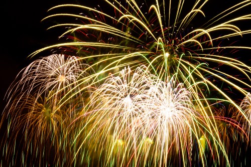 Colorful fireworks burst in the night sky, creating a vibrant display of light and patterns.