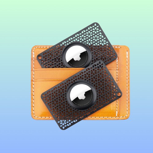 Two black decorative lens filters on a brown leather cardholder, set against a gradient background.