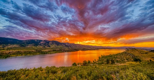 A fiery, colorful sunset over Horsetooth Reservoir in Colorado.