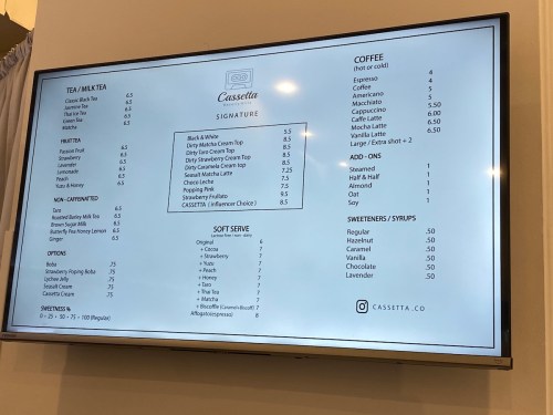 Menu board displaying tea, coffee, and dessert options with prices at Cassetta.
