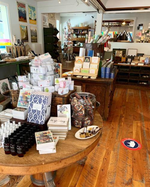 A cozy shop interior filled with various gifts, stationery, and home goods on wooden tables and shelves.