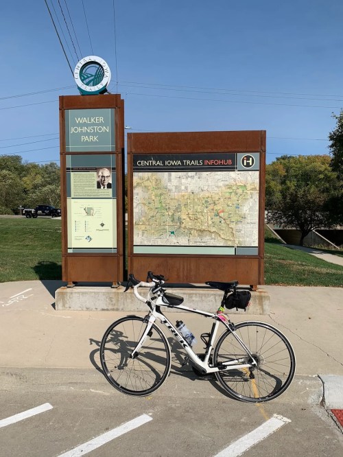 A bike parked next to a trail map and information sign at Walker Johnston Park in Central Iowa.