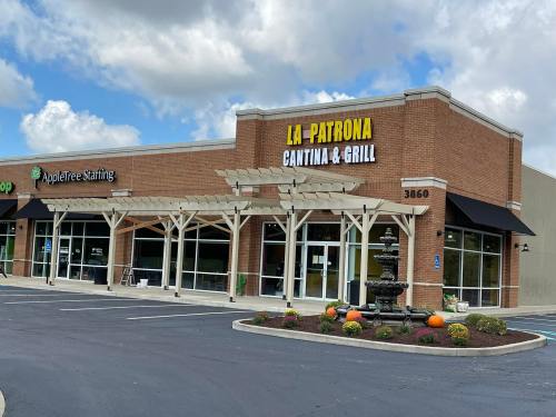 Exterior of La Patrona Cantina & Grill, featuring a fountain and seasonal decorations, in a shopping plaza.