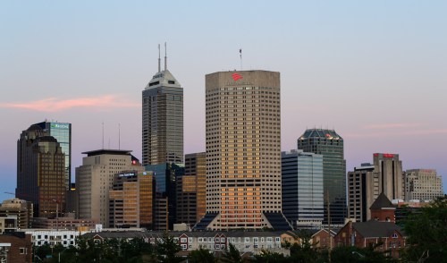 City skyline at dusk featuring tall buildings and a colorful sky.