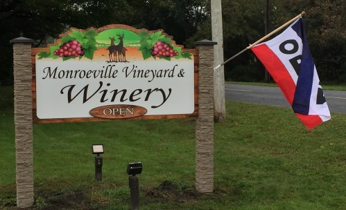 Sign for Monroeville Vineyard & Winery with an "OPEN" flag waving beside it.