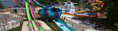A vibrant water park featuring colorful slides, a lazy river, and children enjoying the attractions on a sunny day.