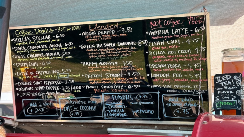 A chalkboard menu featuring various coffee drinks, smoothies, and teas with prices listed.