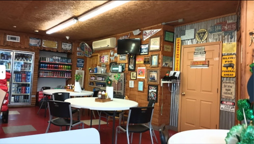 Cozy diner interior with wooden walls, tables, and various vintage signs and memorabilia on display.