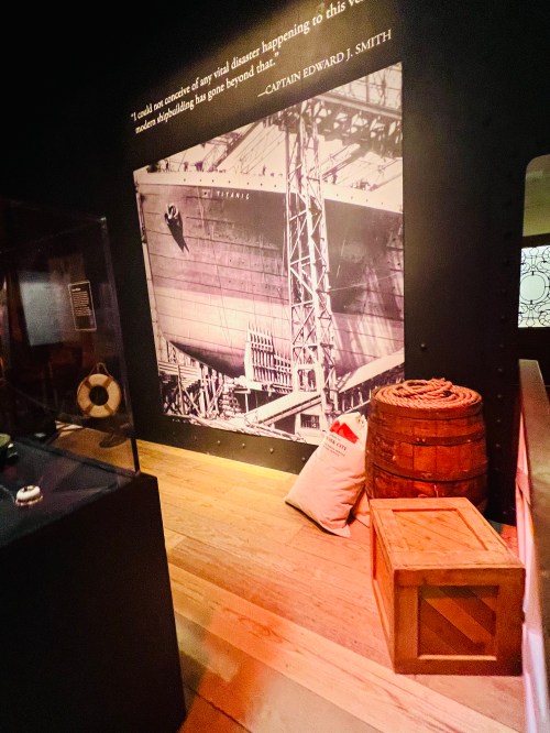 A historic photo of a ship under construction, with a quote from Captain Edward J. Smith displayed on the wall.