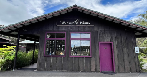 Exterior of Volcano Winery featuring a dark wooden building with purple accents and large windows.