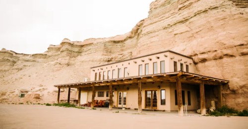 The exterior of a unique Airbnb built into the side of a cliff wall in Hanksville, Utah.