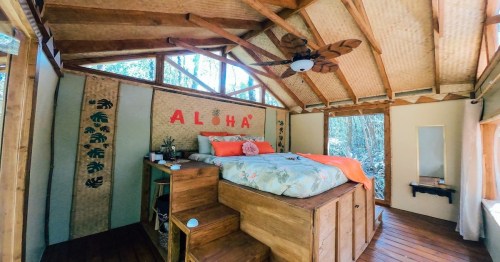 interior view of a platform bed with a ceiling fan and a sign that says aloha