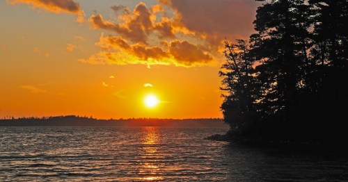 Vibrant golden sunset over the water at Basswood Lake in the Boundary Waters Canoe Area, Minnesota.