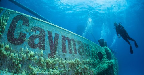 a SCUBA diver checks out the cayman shipwreck at the cayman islands