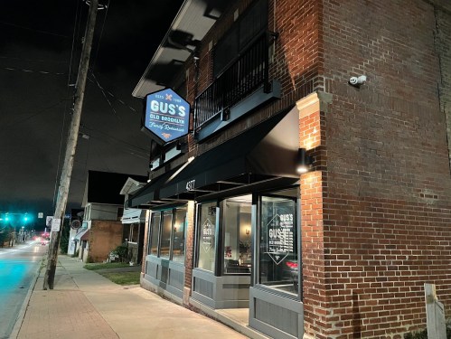 Exterior of Gus's Old Brooklyn restaurant at night, featuring a brick facade and illuminated sign.