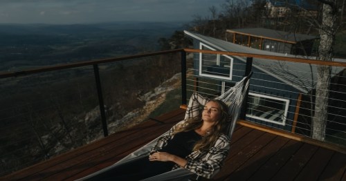 woman lying down on hammock on a rooftop deck in georgia