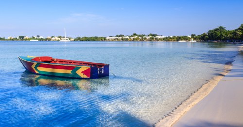 a boat painted in jamaican flag colors at bloody bay beach in jamaica