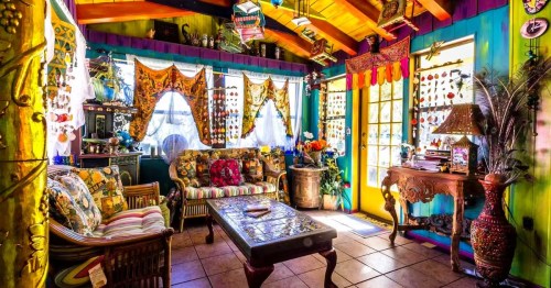 Colorful and eclectic living room with a vibrant design, with lots of artsy decoration at a quirky Airbnb in Florida.