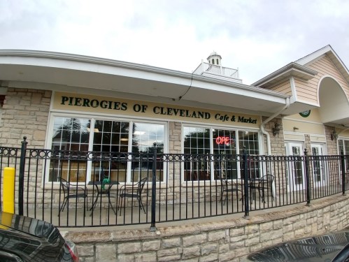 Exterior of "Pierogies of Cleveland Cafe & Market," featuring large windows and an "Open" sign.