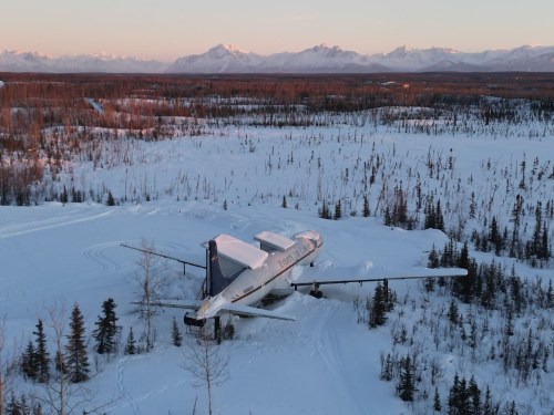 plane airbnb situated in the middle of snowy ground in alaska