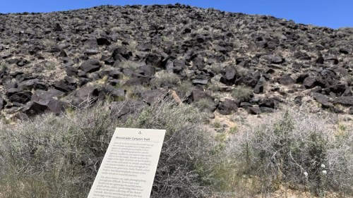 A rocky hillside with sparse vegetation and a sign for the Rinconada Canyon Trail in the foreground.