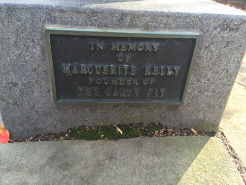 Bronze plaque honoring Marguerite Kelley, founder of The Sassy Cat, set in stone.