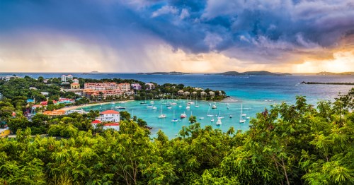 aerial shot of hotels surrounding and boats in cruz bay at st. john, us virgin islands with storm clouds overhead