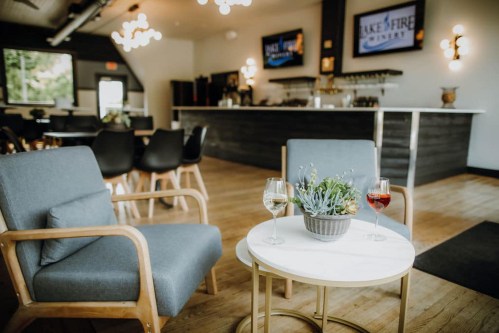 A cozy seating area with two chairs, a small table, and drinks, set in a modern bar with a welcoming atmosphere.