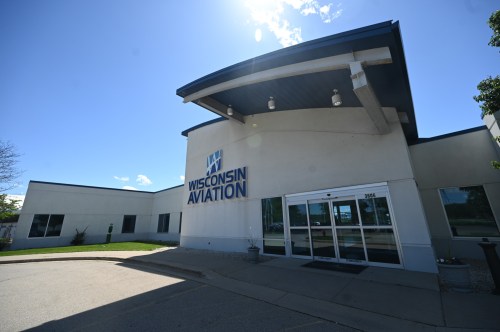 Exterior of Wisconsin Aviation building with a clear blue sky and green landscaping.